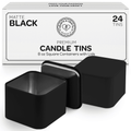 Two square black candle tins with lids in front of white box packaging on a white background - closeup view