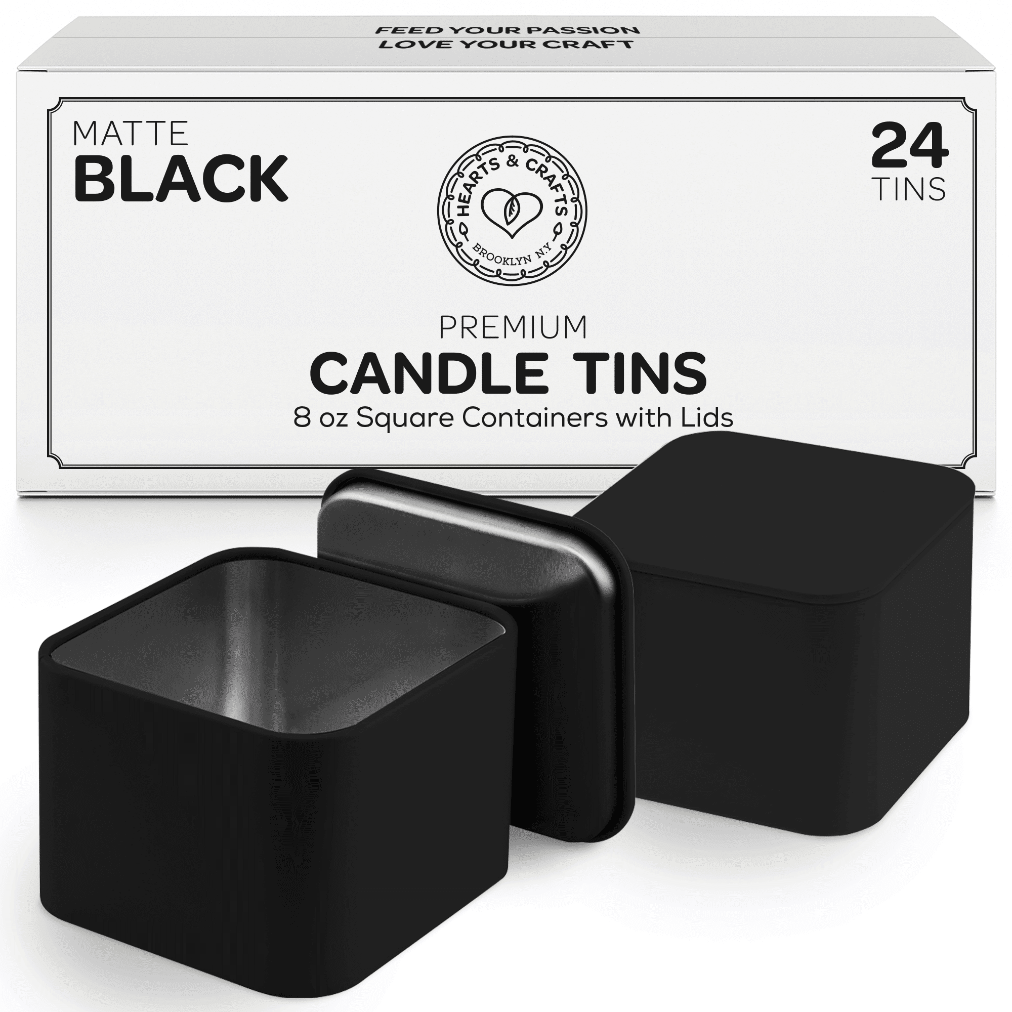 Two square black candle tins with lids in front of white box packaging on a white background - closeup view