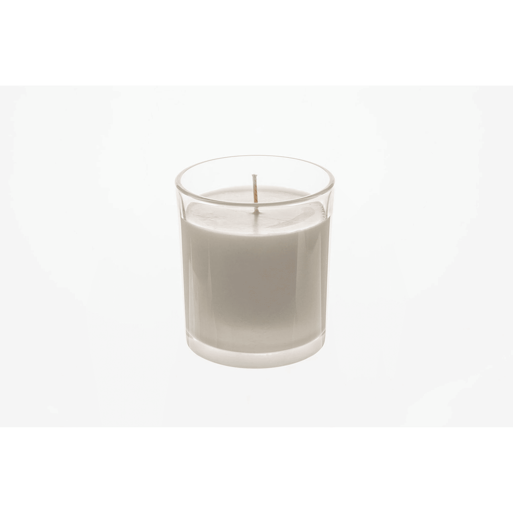 White candle in a clear glass container on a white background