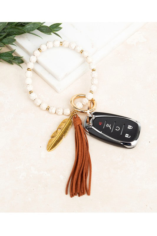 Cream stone bangle key ring bracelet with cognac suede tassel and feather charm - boho hands-free key holder jewelry