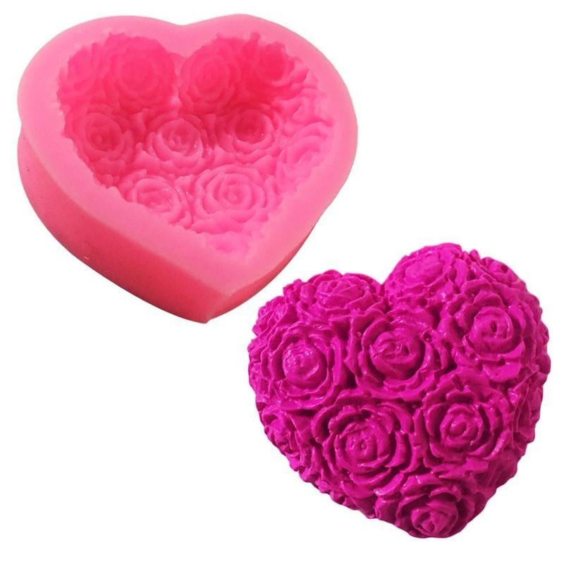 Pink heart-shaped silicone mold with an embossed rose pattern next to a beautiful heart that has been demolded on a white background