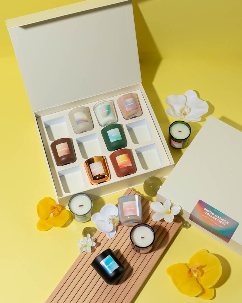 Collection of small candles in cream magnetic gift box with decorative flowers on yellow background - handmade candle presentation