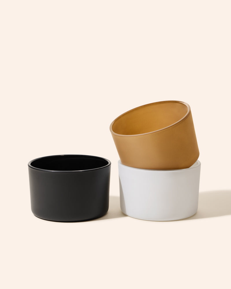 Three 18oz Dream Candle Vessels in Matte Black, White, and Taupe ceramic on beige background - premium candle making containers