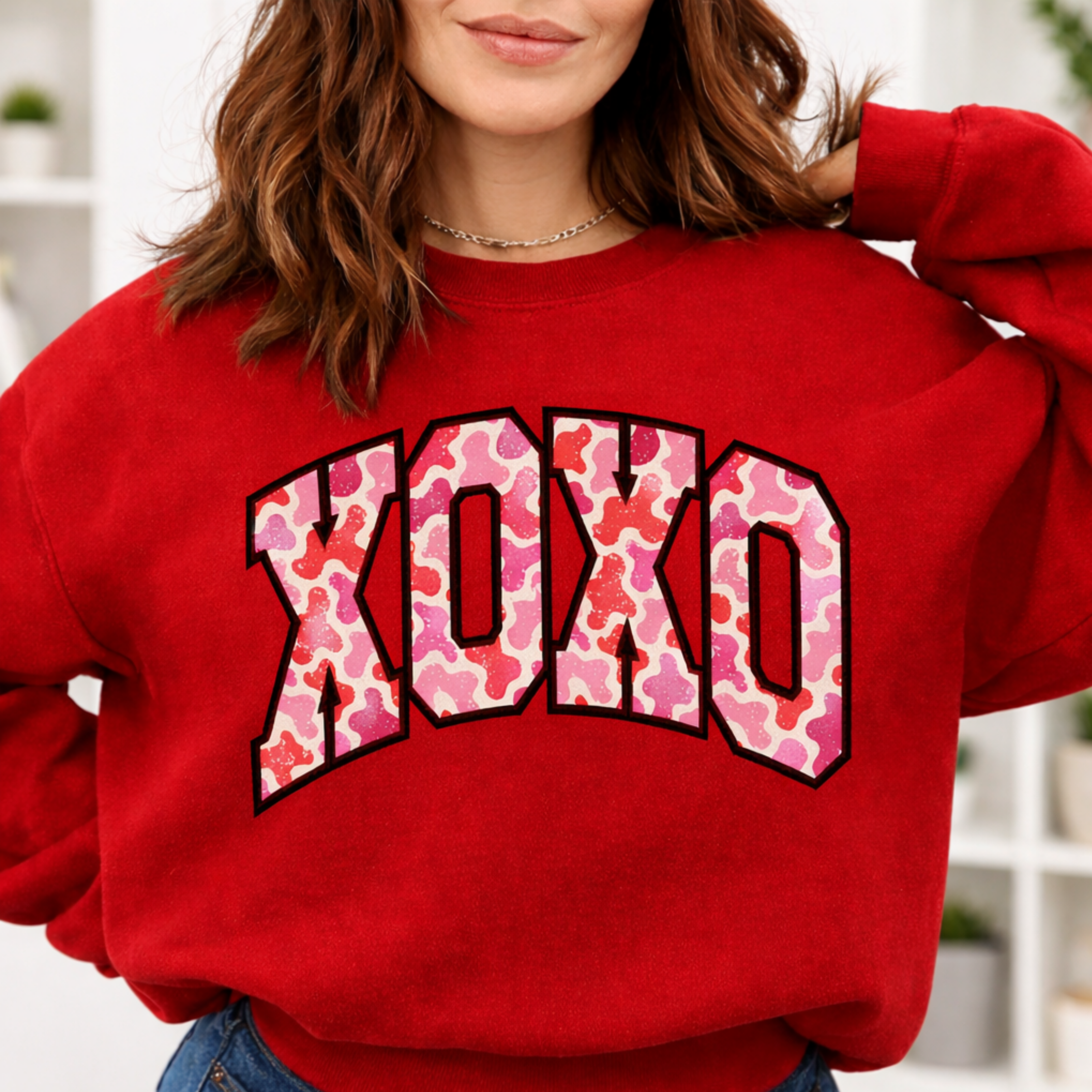 Person wearing red XOXO sweatshirt with pink leopard print text for Valentine's Day gift
