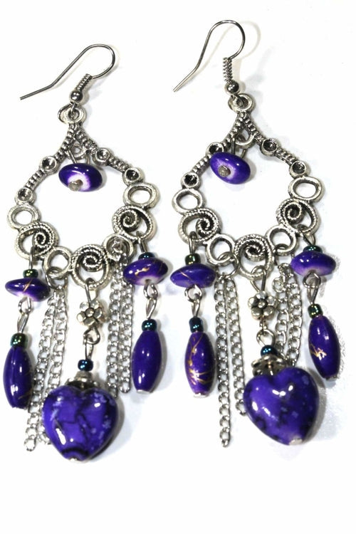 Pair of purple marbled bead dangle earrings with silver scroll work and chains on white background
