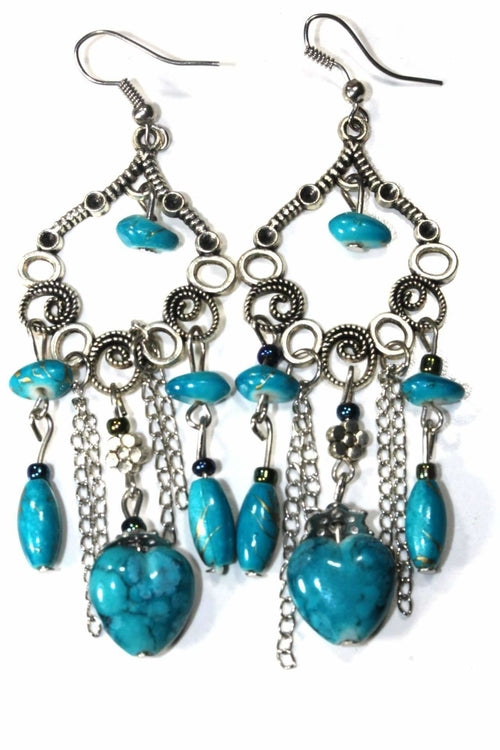 Pair of turquoise marbled bead dangle earrings with silver scroll work and chains on white background