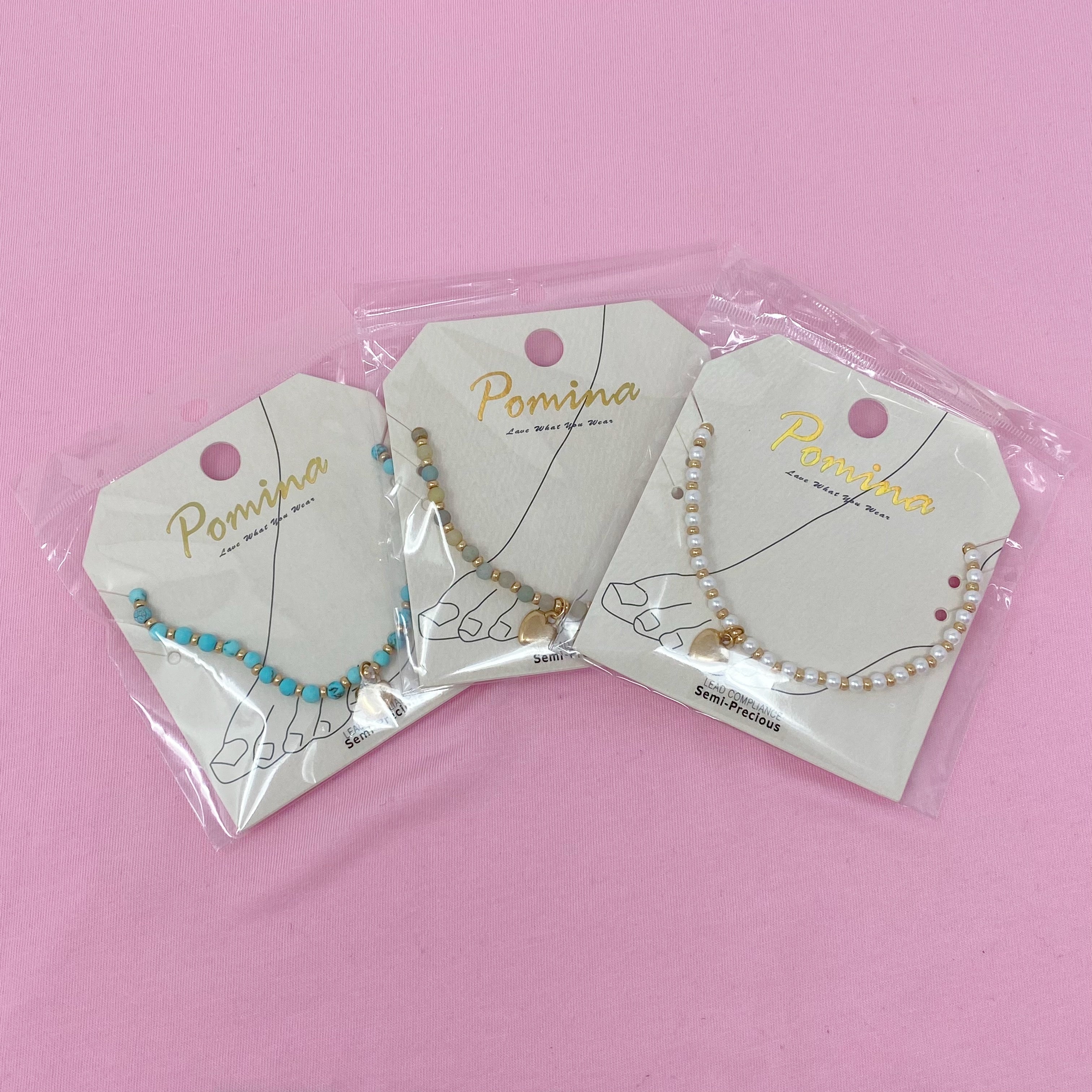 Three stone bead heart anklets in clear packaging on jewelry cards - pearl, turquoise, amazonite Valentine's Day gifts