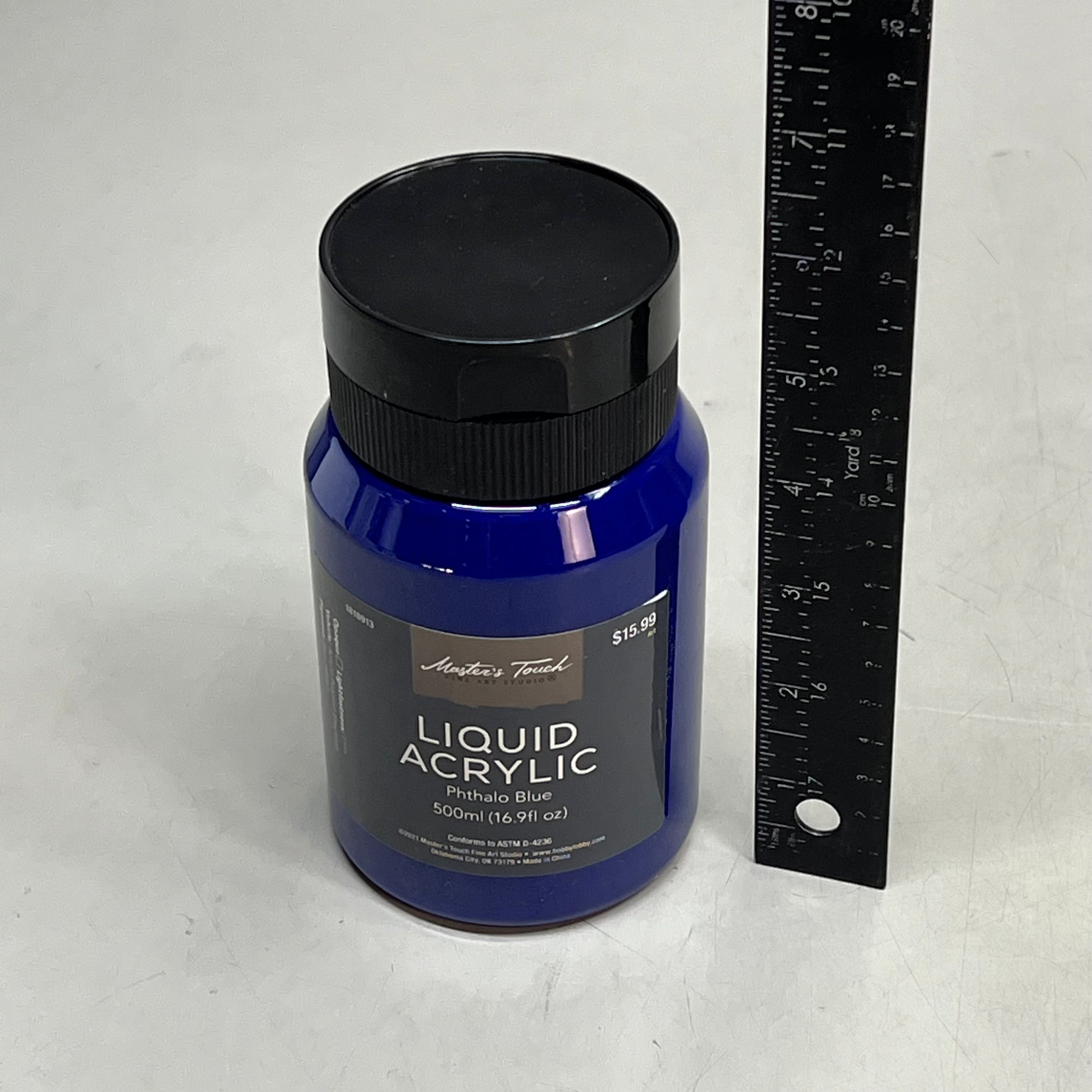Master's Touch Liquid Acrylic Phthalo Blue paint bottle with black lid next to ruler showing size comparison on white background - 16.9 oz dark blue acrylic paint