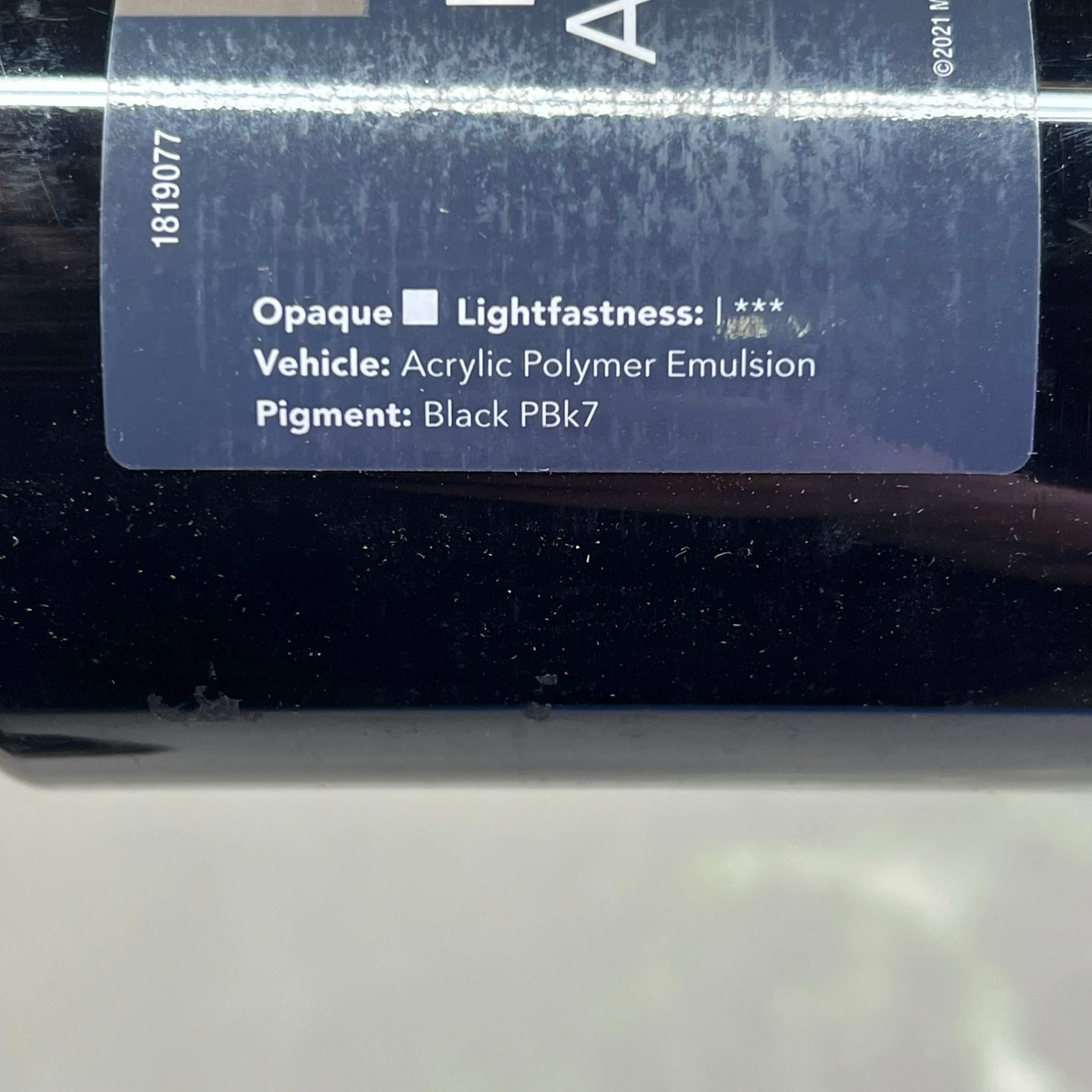 Side of Master's Touch Liquid Acrylic Paint bottle label with technical specifications on black surface - permanent black paint details