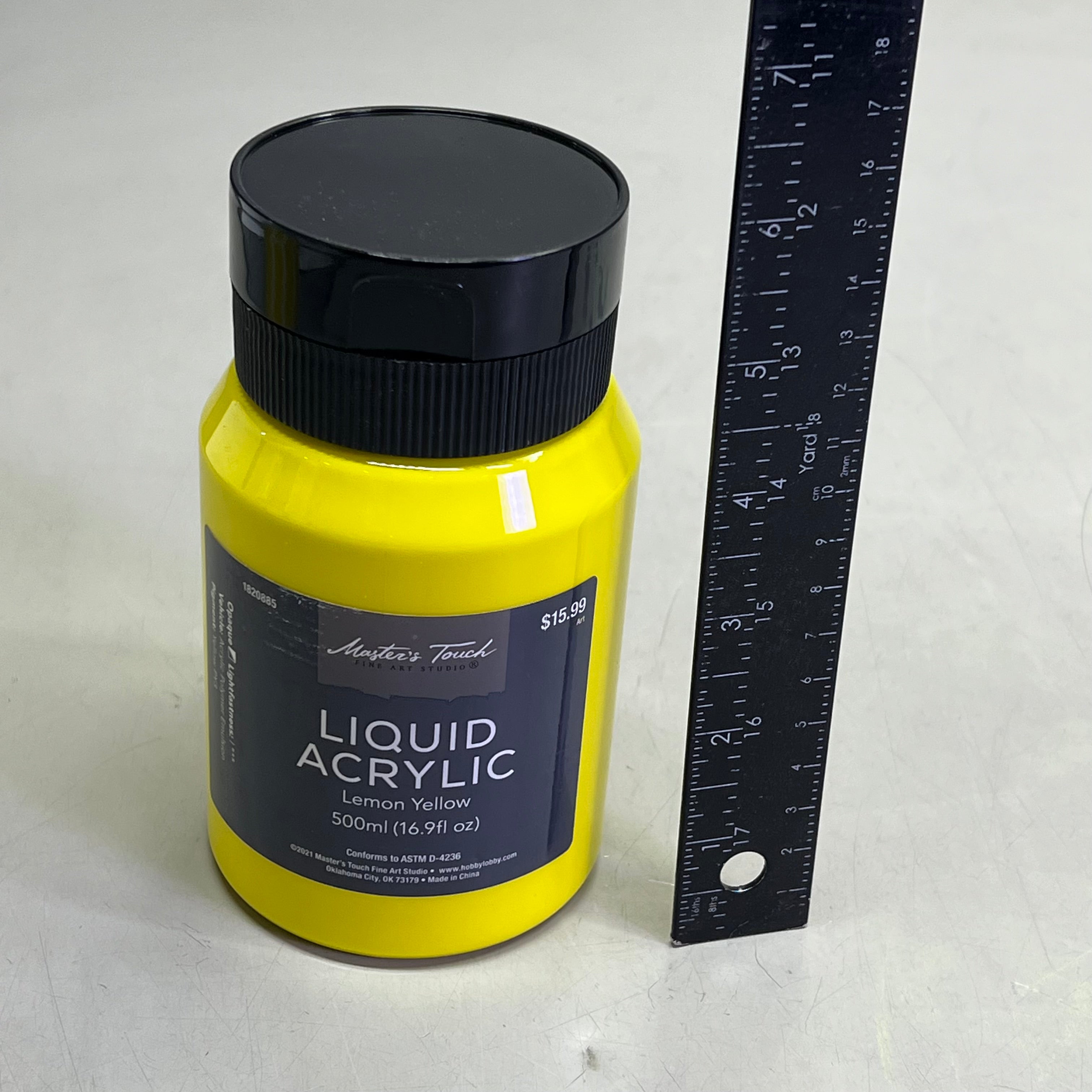 Yellow bottle of Master's Touch Liquid Acrylic Paint next to ruler for scale on white background - 16.9 fl oz lemon yellow acrylic