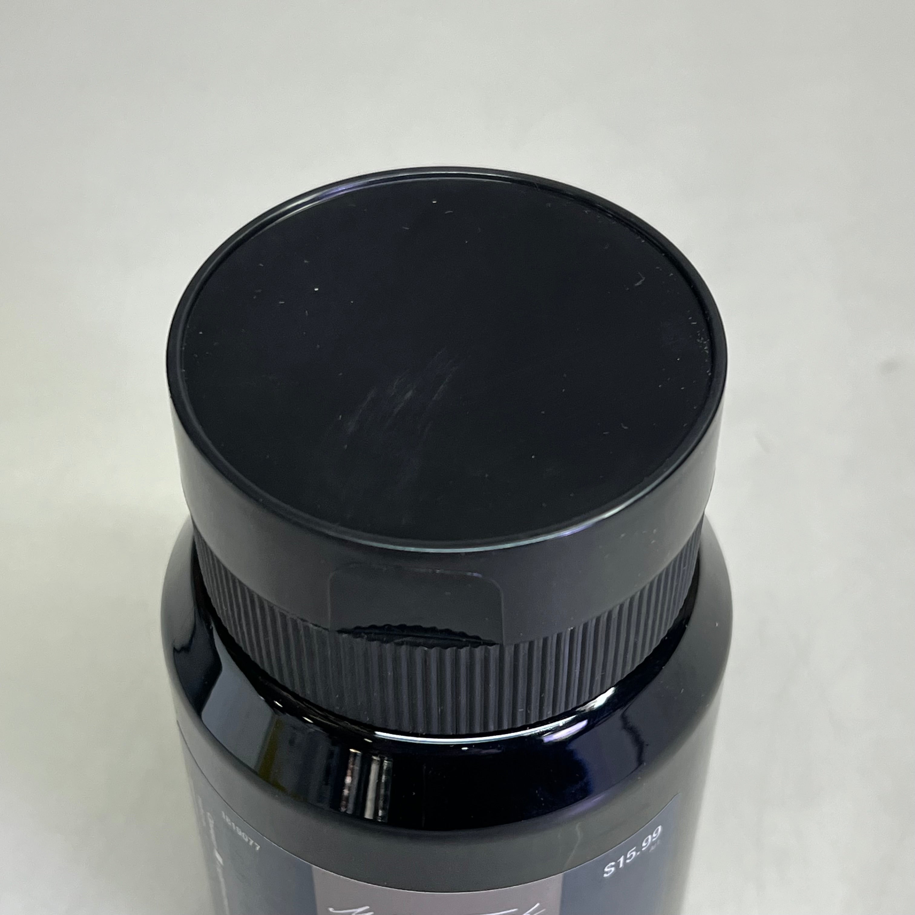 Close up of black bottle cap on Master's Touch Liquid Acrylic Paint bottle on white background - permanent black acrylic