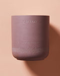 Scent of Nirvana meditation candle in rose-colored container with white wax and CAFTARI branding on peach background
