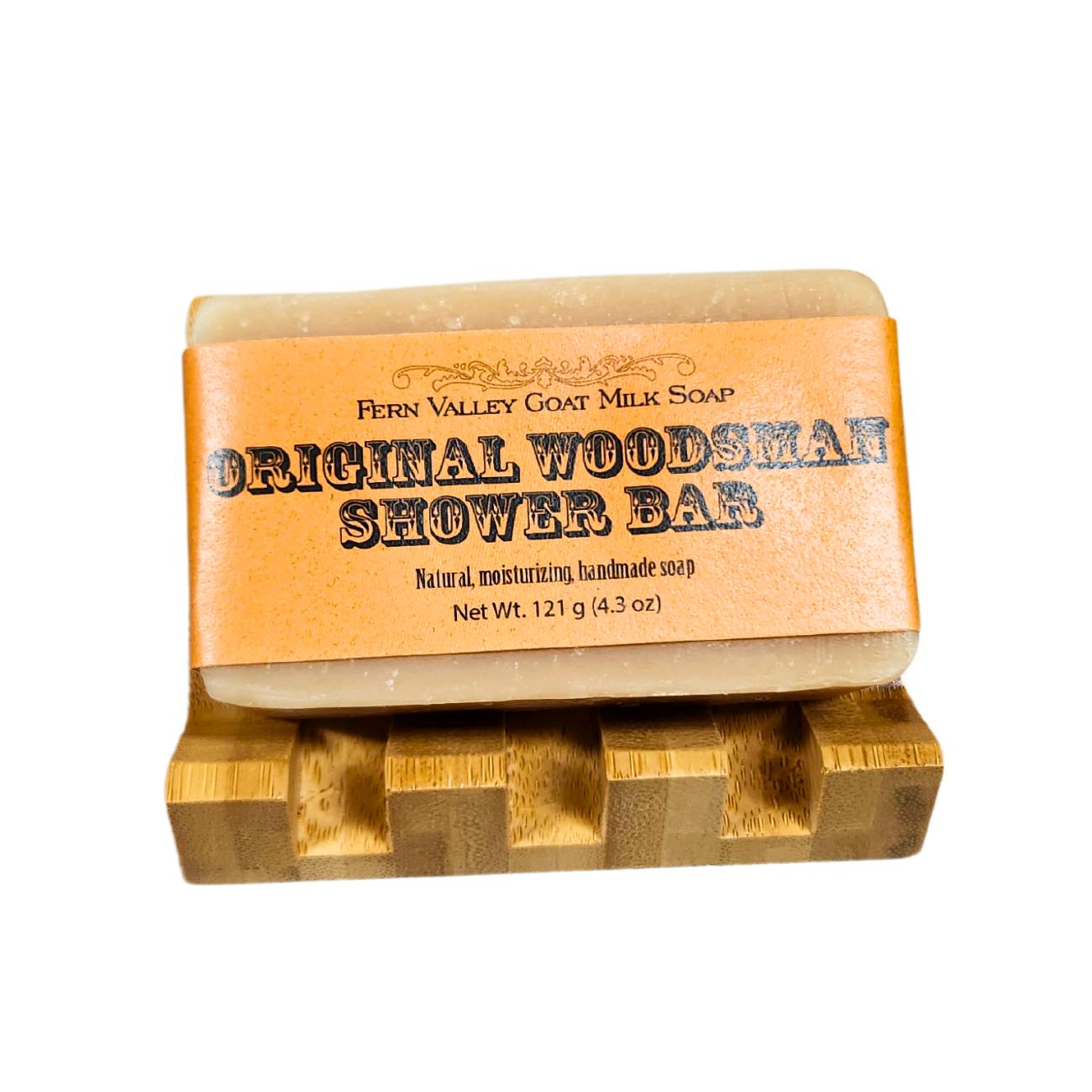 Bar of Original Woodsman Shower Soap with label on wooden block against white background