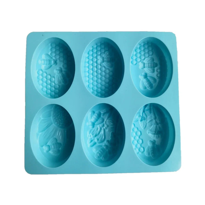Blue silicone soap mold with bees, flower and honeycomb designs on a white background