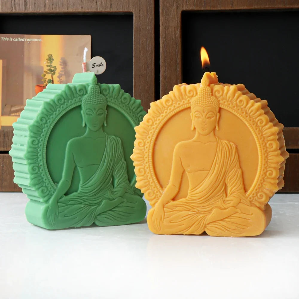 Two Buddha-shaped candles, one green and one yellow, on white surface with blurred background - handmade candles from silicone mold