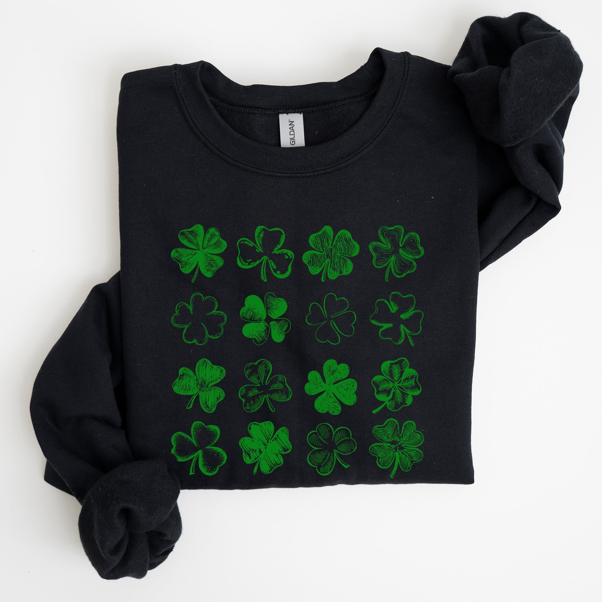 Black sweatshirt with green clover patterns on a white background