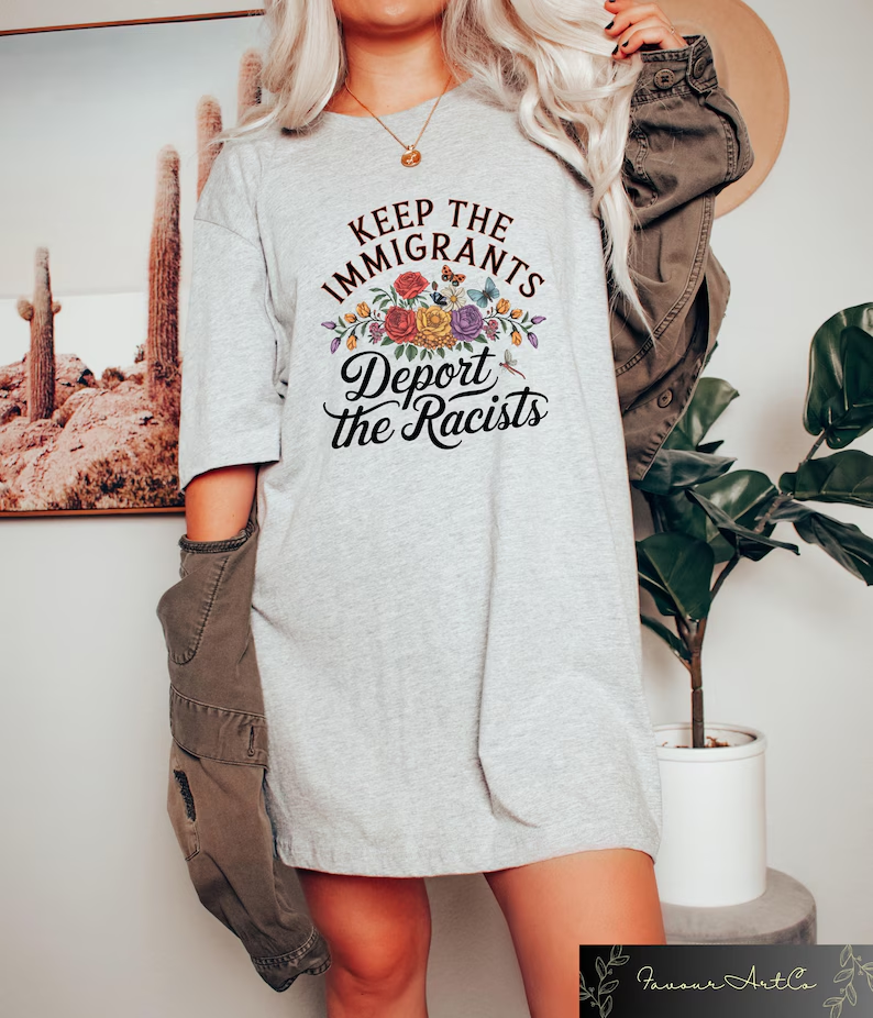 Person wearing ash gray t-shirt with 'Keep the Immigrants Deport the Racists' political message design