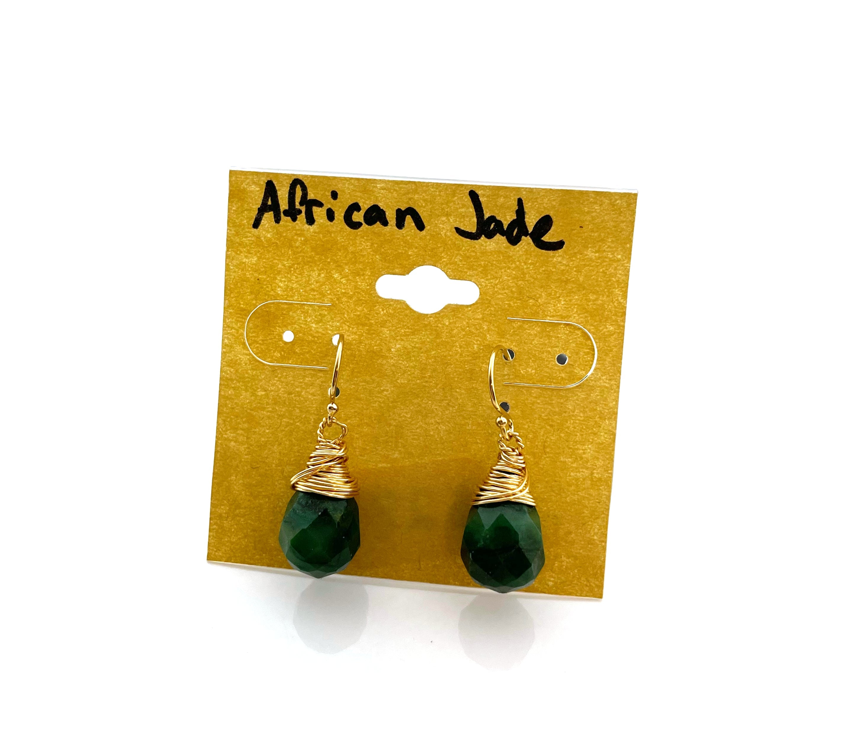 Green earrings on a gold card labeled 'African Jade' against a white background