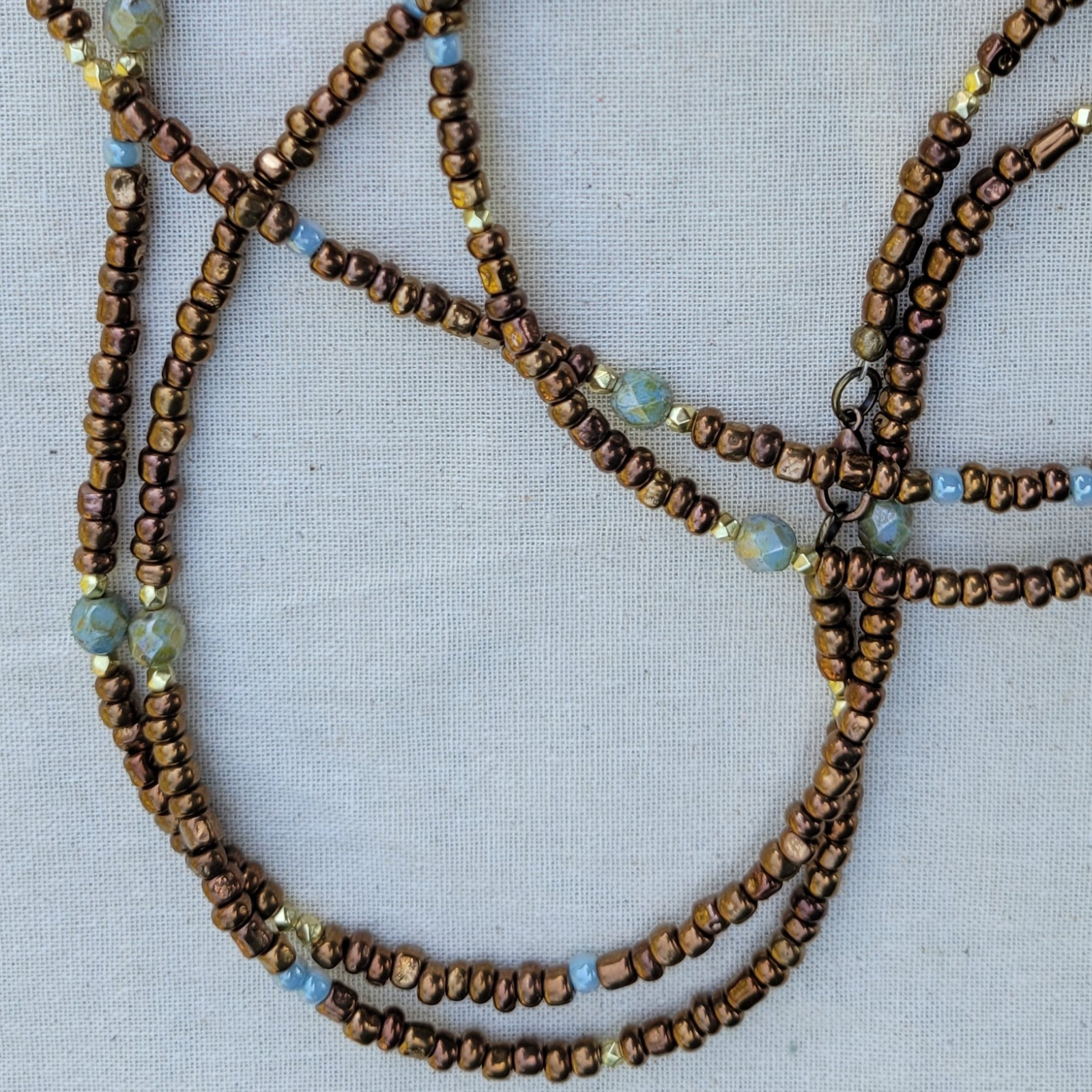 Boho beaded wrap bracelet slightly unwrapped showing continuous strand - brown, blue and gold glass bead jewelry