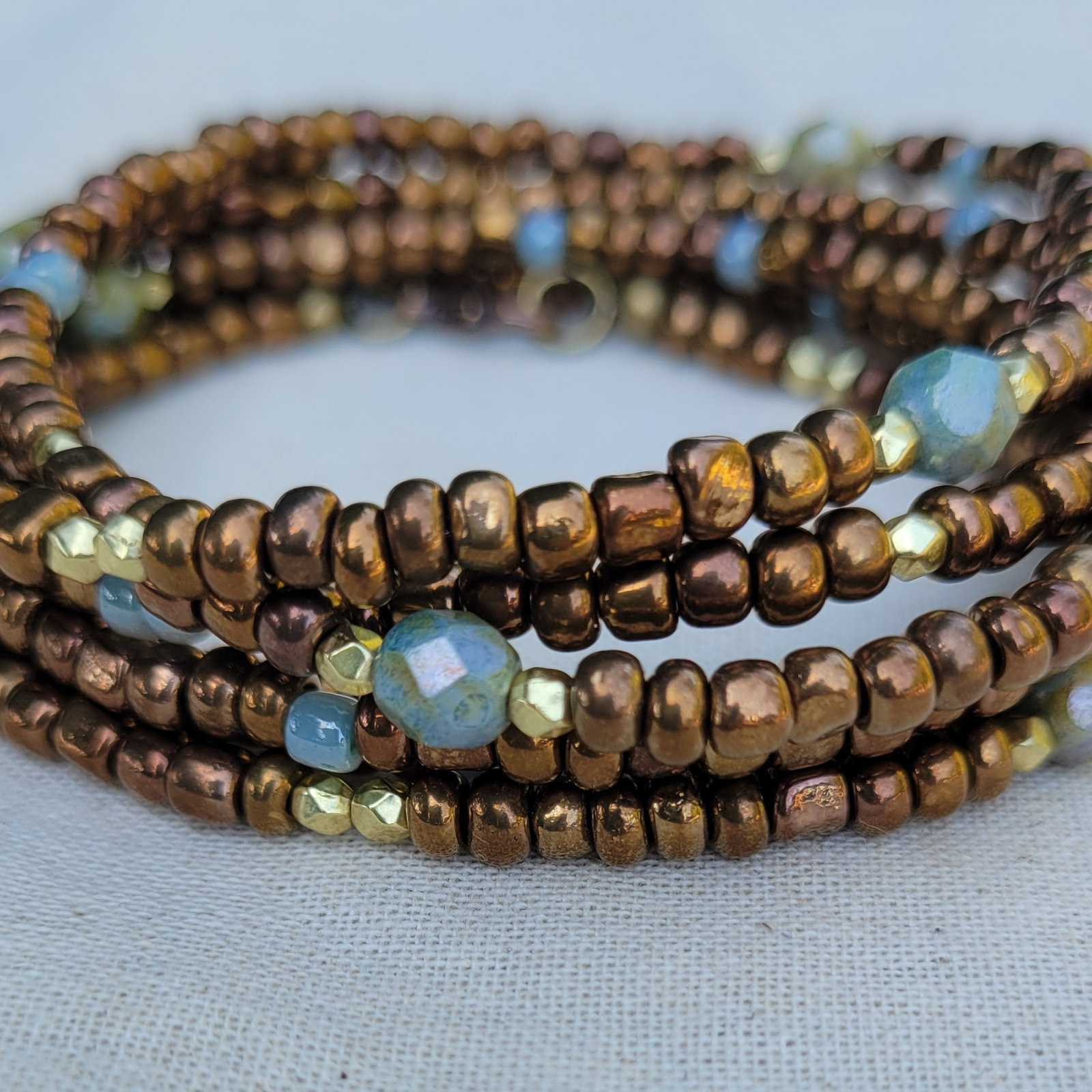 Earthy wrap bracelet with brown, blue and gold glass beads - boho layered statement jewelry from different angle