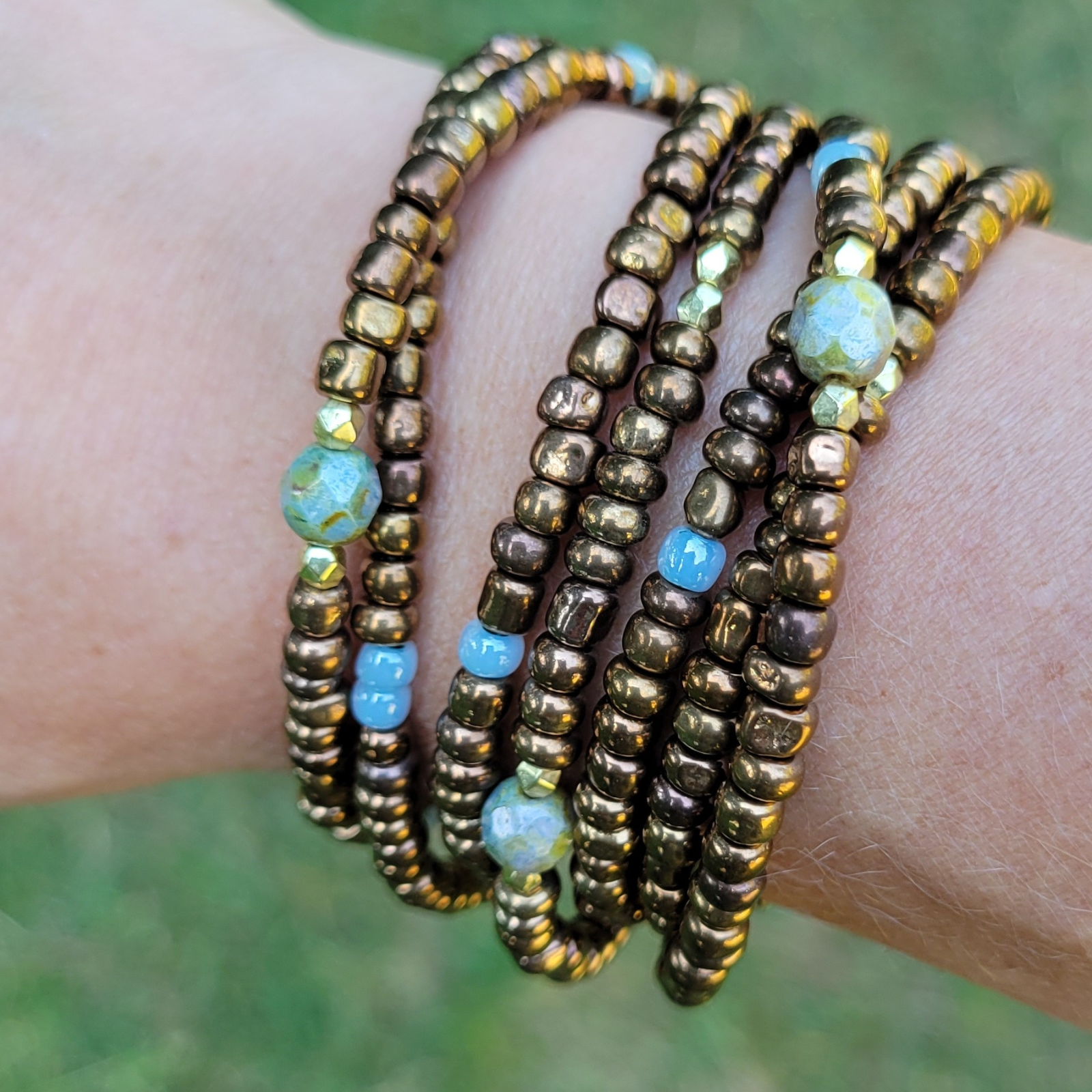 Boho glass beaded wrap bracelet on wrist - brown, blue and gold adjustable layered jewelry by Blue June Outfitters