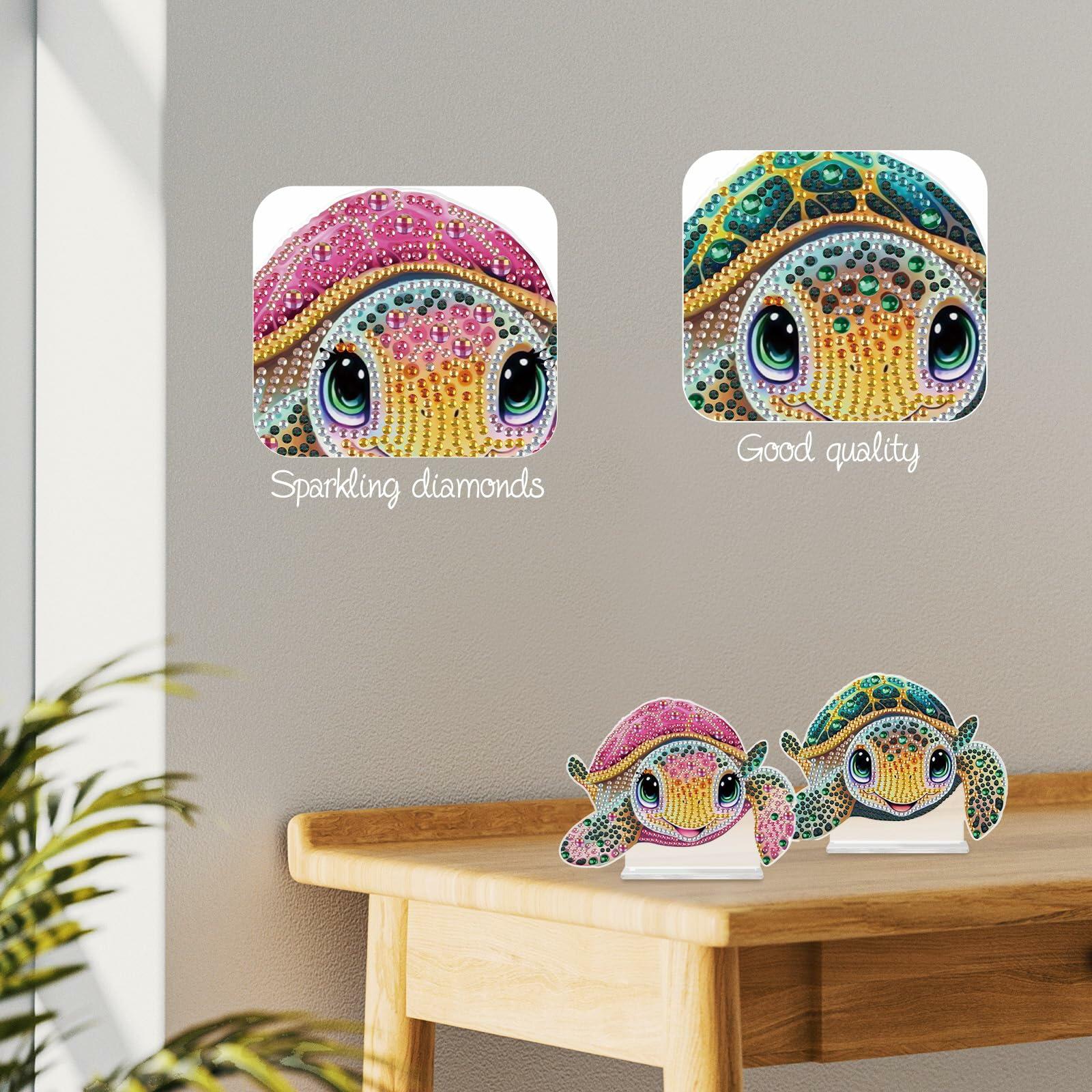 Closeup of two diamond painting turtles showing sparkling gemstones and two finished turtle decorations on a wooden surface with a neutral background.