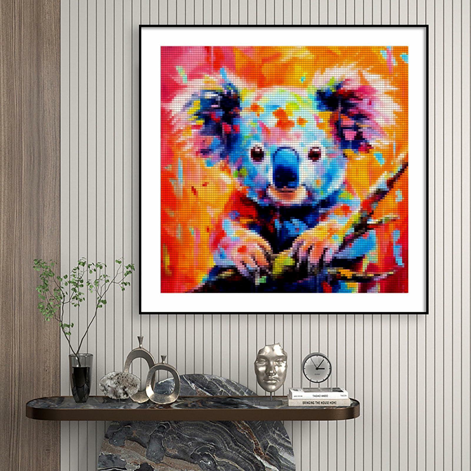 Colorful framed koala diamond painting on a wall above a decorative shelf.