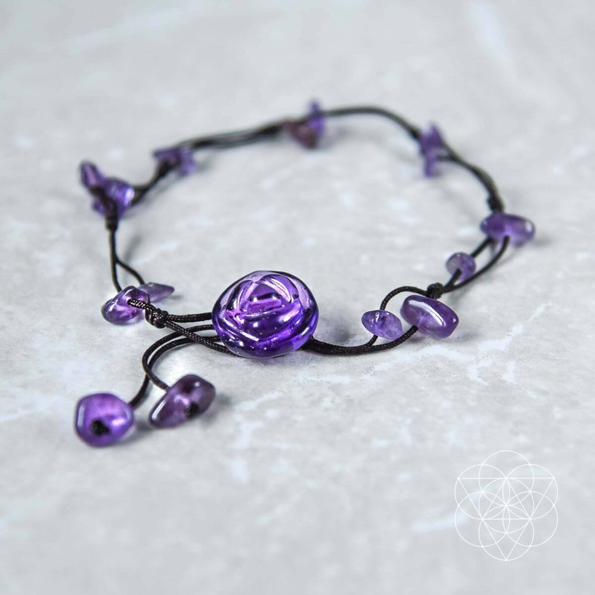 black cord anklet with natural purple amethyst beads and large purple rose-shaped focal bead on a white background