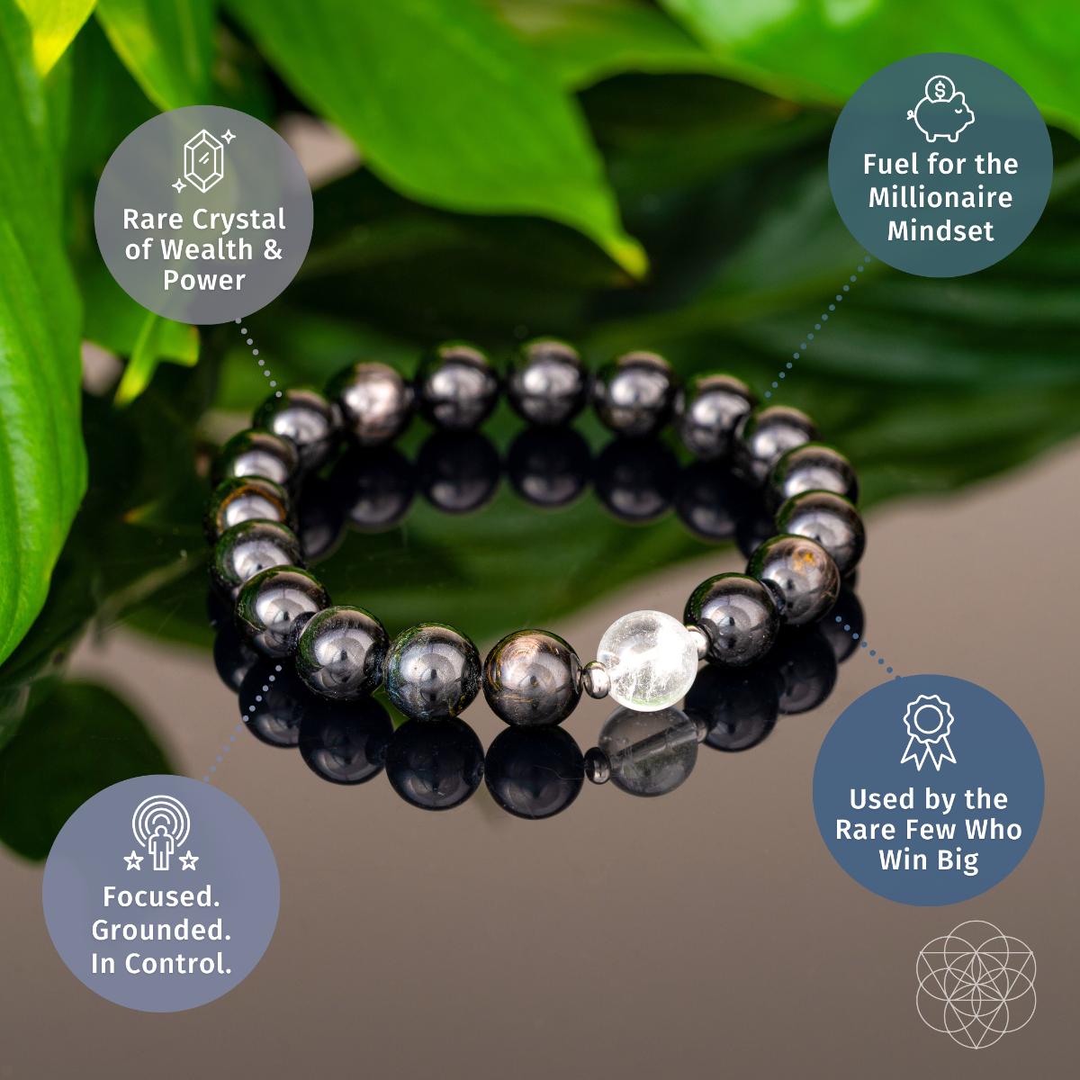 Black hypersthene beaded bracelet with clear crystal center bead on green leaf background - prosperity jewelry