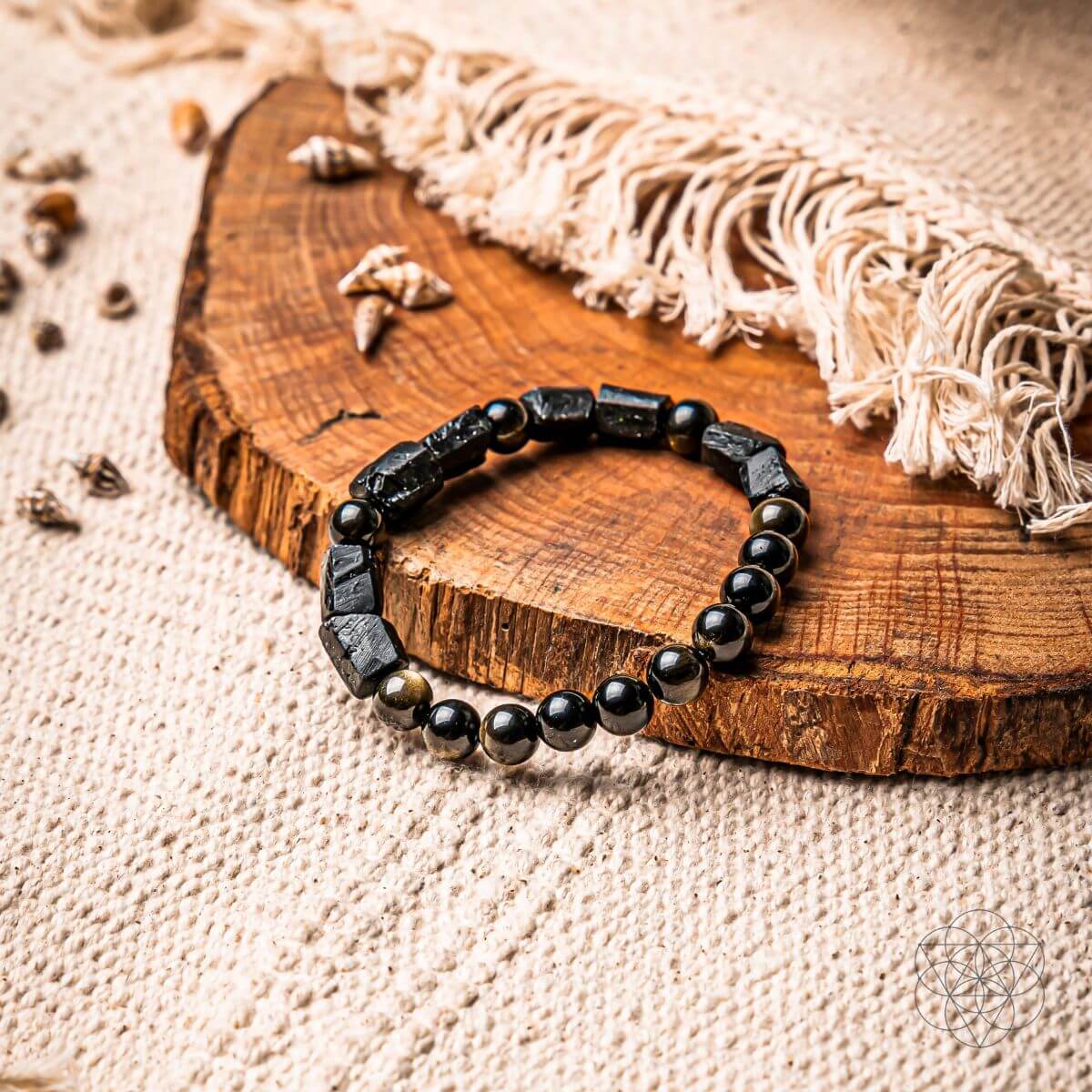 Black beaded spiritual protection bracelet on wooden surface with natural elements - healing crystal bracelet