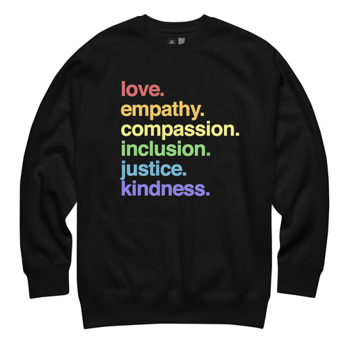 Black crewneck sweatshirt with 'love empathy compassion inclusion justice kindness' text in colorful rainbow letters on white background - LGBTQ+ pride apparel by Kind Cotton