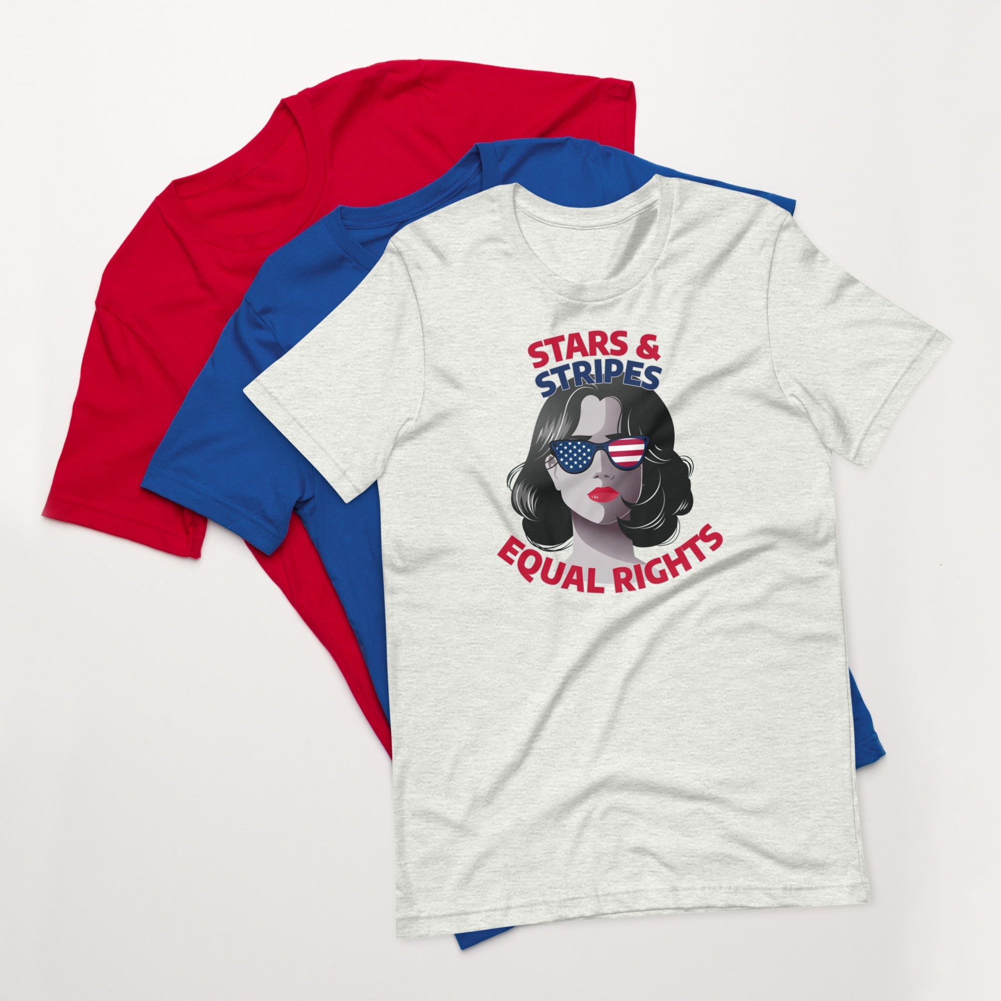 Ash gray unisex t-shirt with stars and stripes equal rights graphic design, displayed on top of fanned red and blue shirts on white background