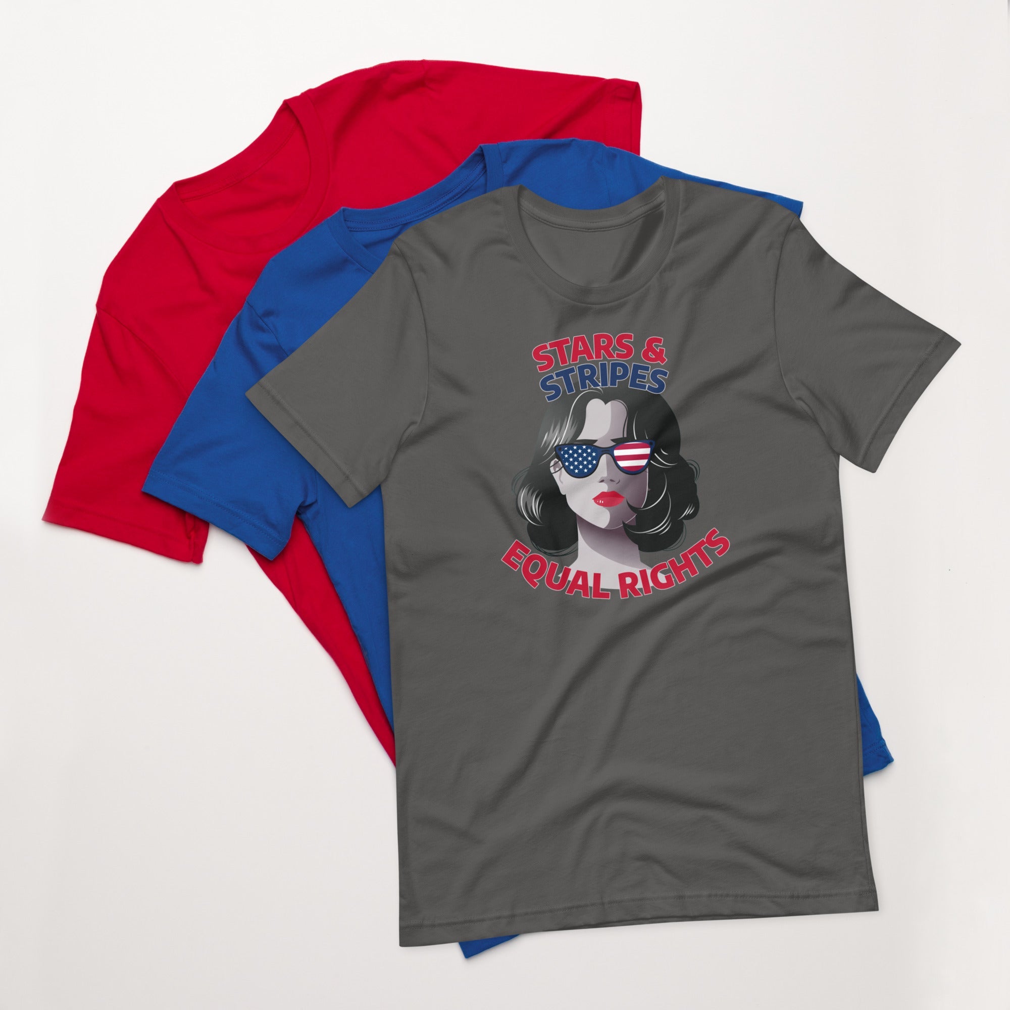 Asphalt gray unisex t-shirt with stars and stripes equal rights graphic design, displayed on top of fanned red and blue shirts on white background