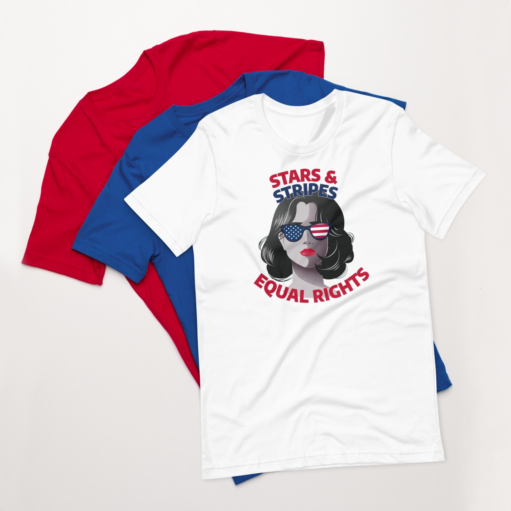 White unisex t-shirt with stars and stripes equal rights graphic design, displayed on top of fanned red and blue shirts on white background