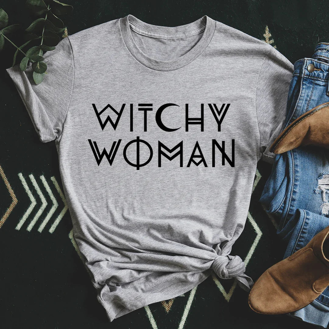 Athletic heather Witchy Woman graphic t-shirt on textured surface with jeans and boots - spiritual boho tee